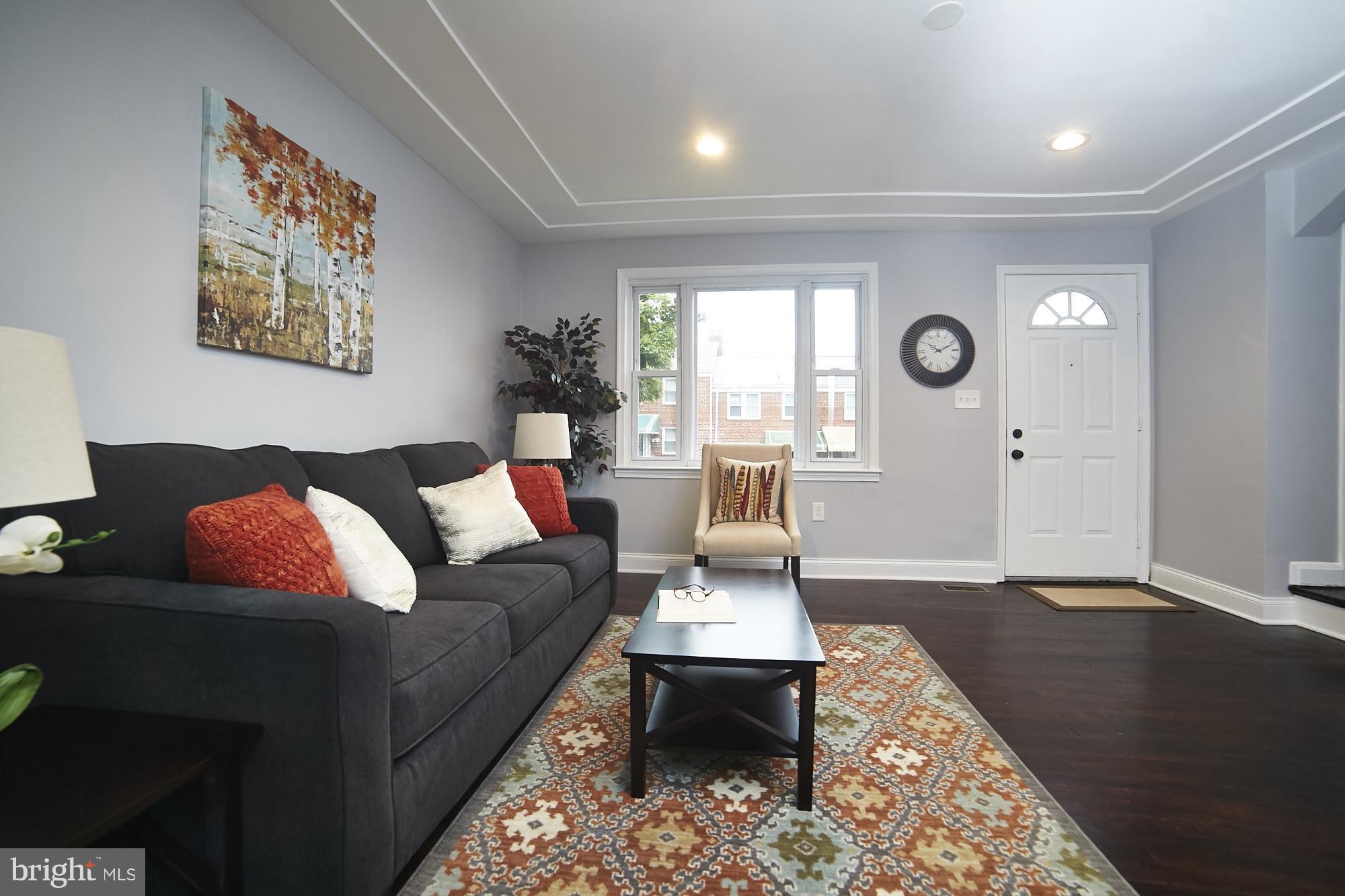 3814 Elkader Road Baltimore, MD 21218 - Photo 4 of 30 a living room with furniture a clock on wall and a window