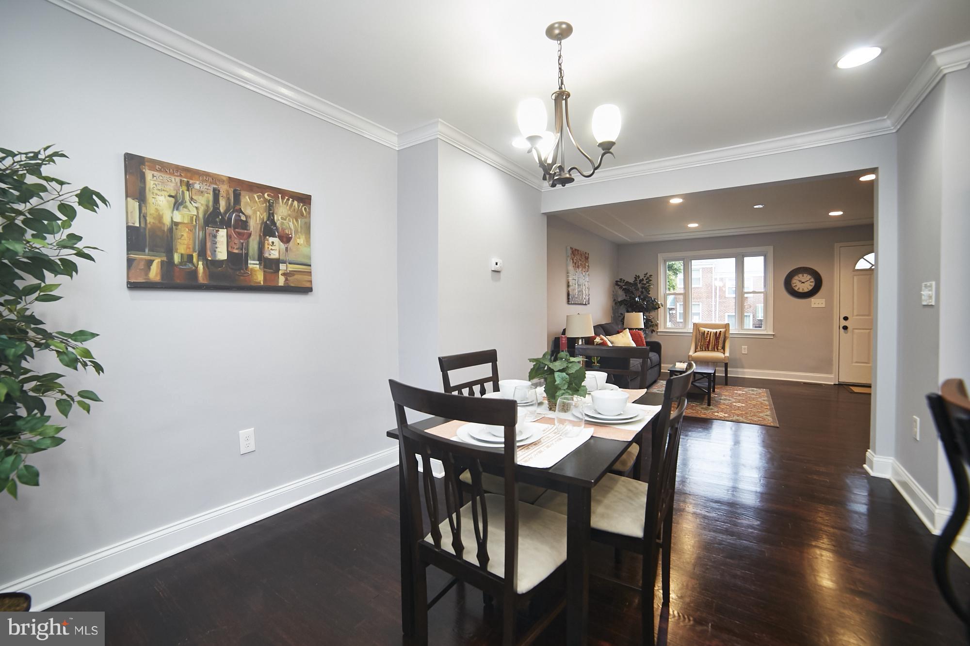 3814 Elkader Road Baltimore, MD 21218 - Photo 7 of 30 a view of a dining room with furniture wooden floor and a chandelier
