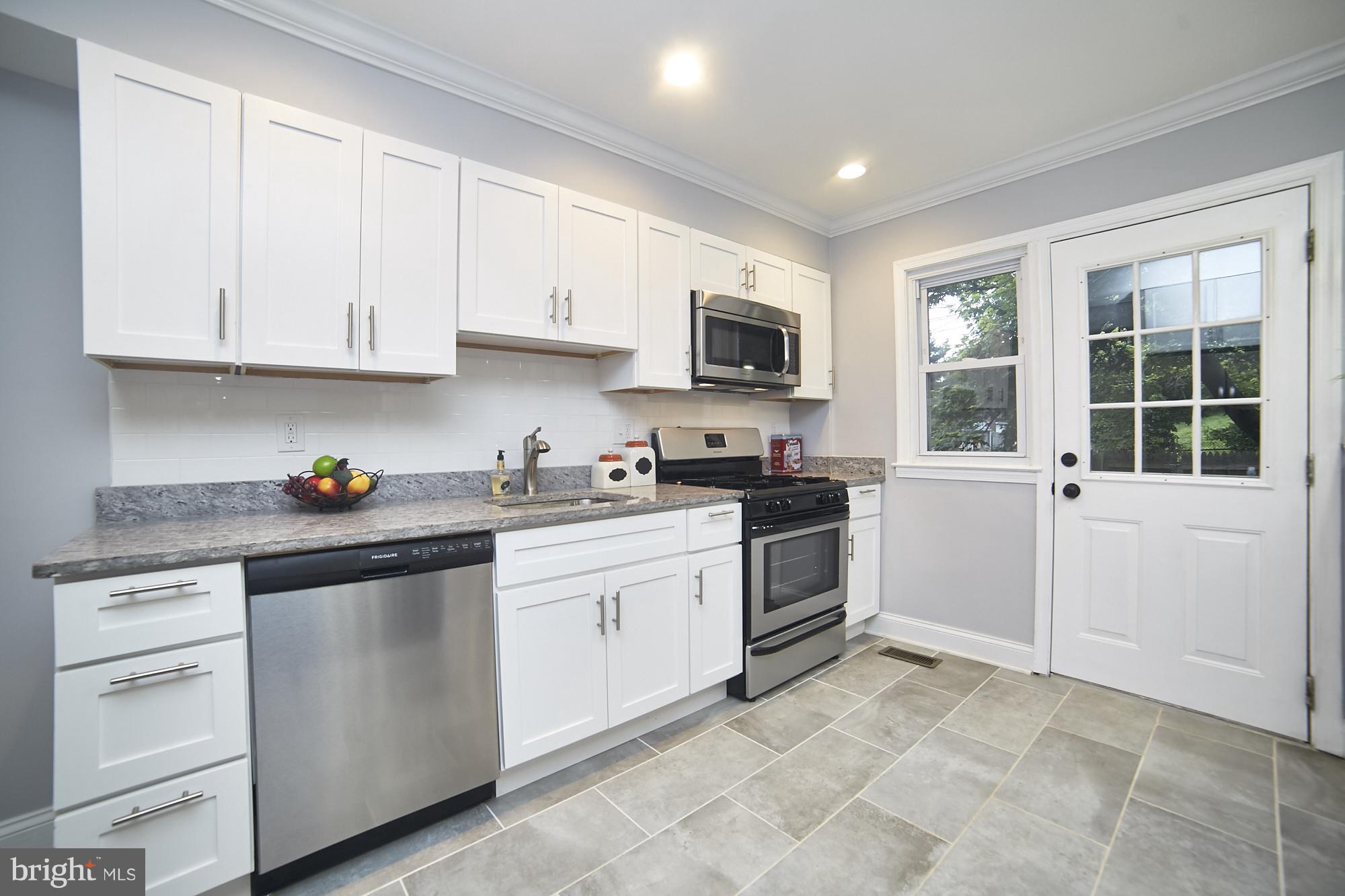 3814 Elkader Road Baltimore, MD 21218 - Photo 8 of 30 a kitchen with granite countertop white cabinets and stainless steel appliances
