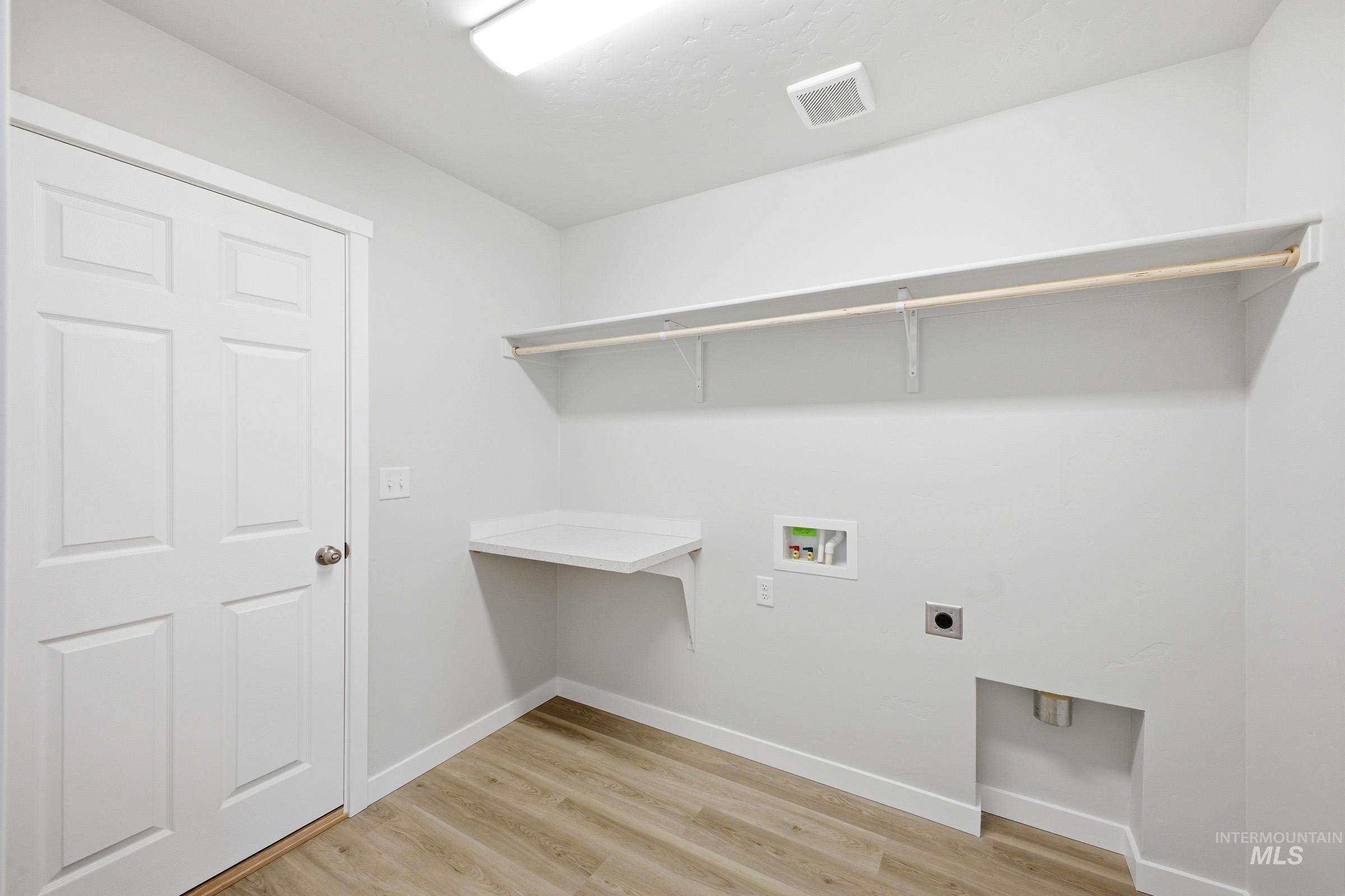 1598 Sunday River Street Middleton, ID 83644 - Photo 13 of 17 Laundry space featuring light wood-finish flooring, white baseboards, and a white six-panel door