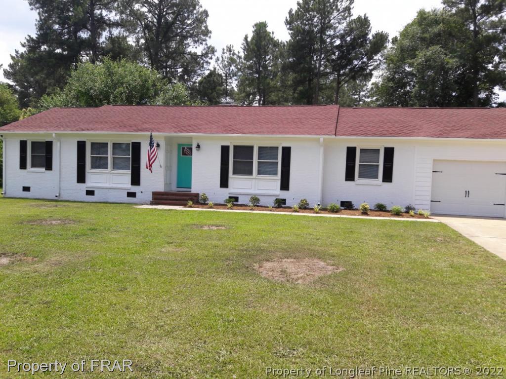 a front view of house with yard and trees
