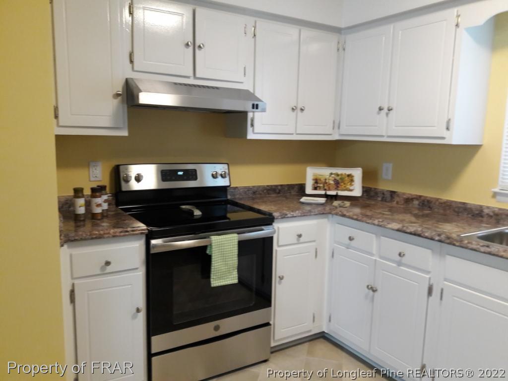 821 Bedford Road Fayetteville, NC 28303 - Photo 3 of 14 a kitchen with granite countertop white cabinets and a stove