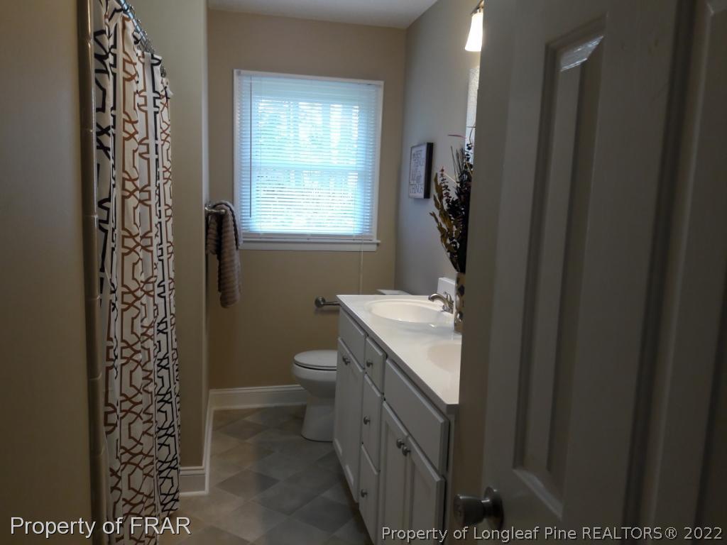 821 Bedford Road Fayetteville, NC 28303 - Photo 9 of 14 a bathroom with a granite countertop sink toilet and shower