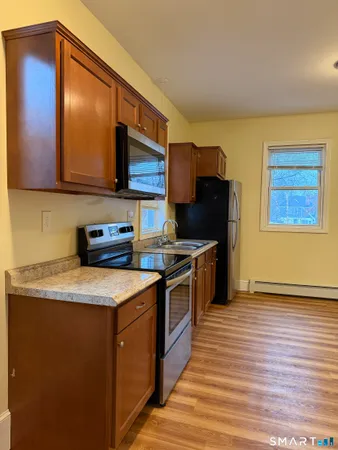 a kitchen with stainless steel appliances granite countertop a stove a sink and a microwave