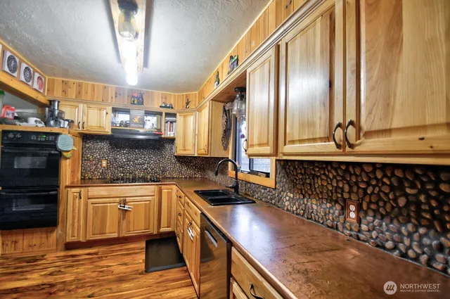 a kitchen with stainless steel appliances granite countertop a sink a stove counter space and cabinets