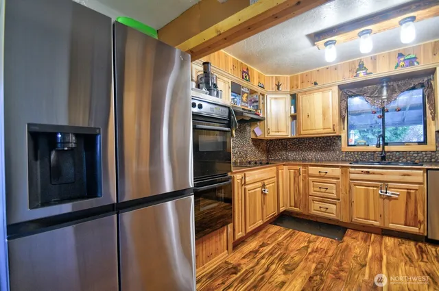 a kitchen with granite countertop stainless steel appliances a refrigerator a sink and cabinets
