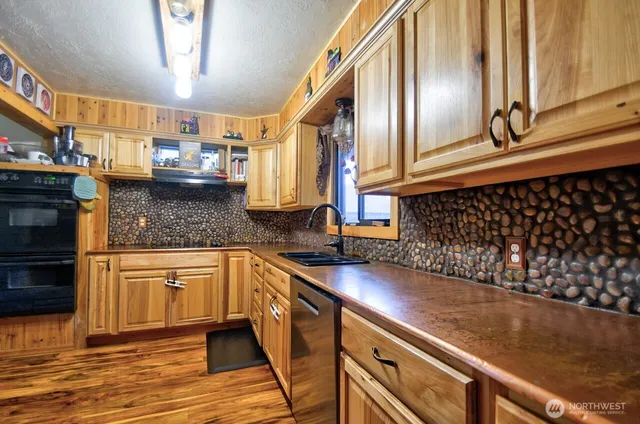 a kitchen with stainless steel appliances granite countertop a sink a stove and cabinets