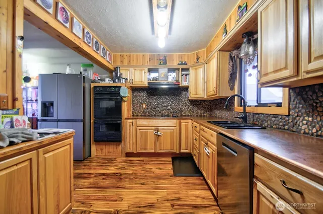 a kitchen with stainless steel appliances granite countertop a sink stove and cabinets