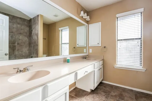 a bathroom with a granite countertop sink and a large mirror