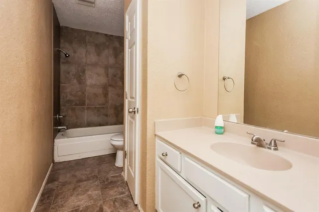a bathroom with a tub sink toilet and a mirror