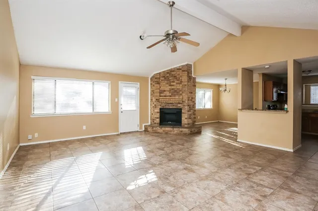 a view of empty room with a fireplace and fan