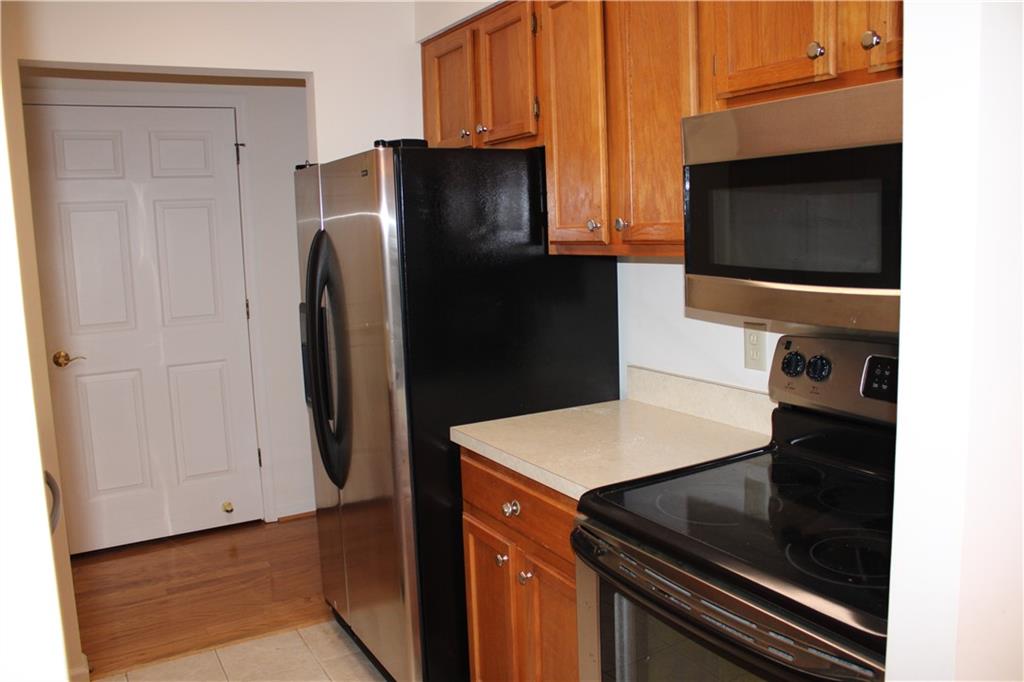 300 Johnson Ferry Road, Unit B802 Atlanta, GA 30328 - Photo 3 of 23 a kitchen with stainless steel appliances a refrigerator a stove a microwave and cabinets