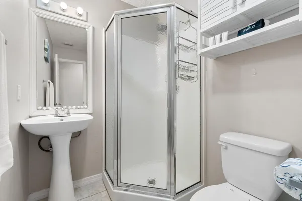 a bathroom with a sink a toilet and shower