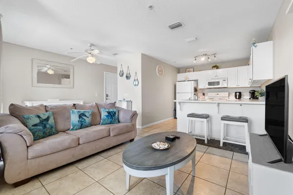 a living room with furniture and a dining table with kitchen view