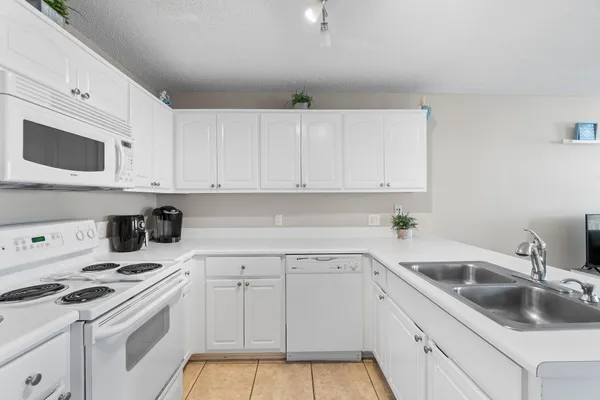 a kitchen with white cabinets sink and white appliances