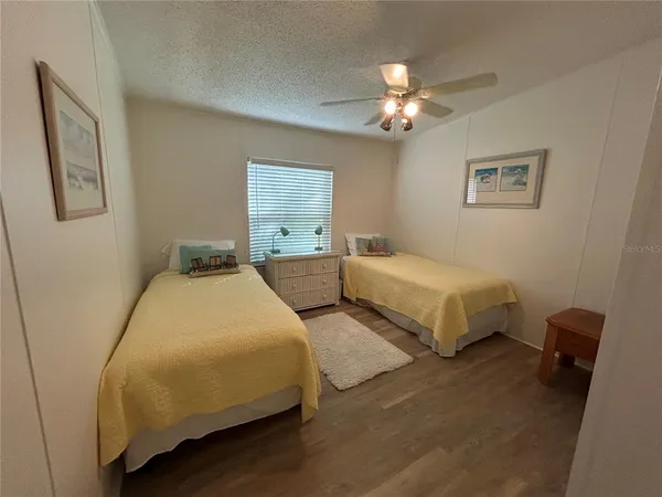 a bedroom with two beds and painting on the wall