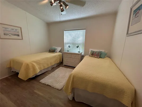 a bedroom with a bed and a flat tv screen on dresser