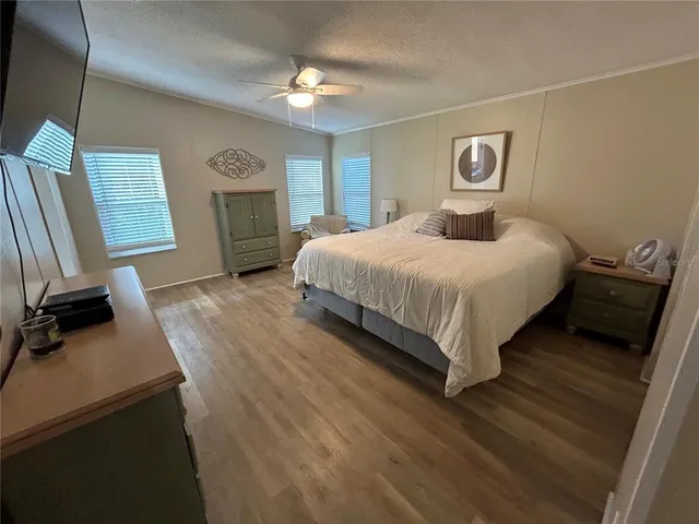 a spacious bedroom with a bed and a chandelier