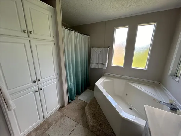 a bathroom with a tub sink and mirror