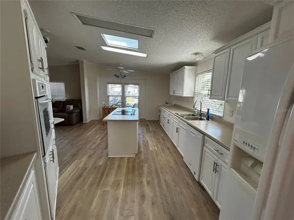 a view of a dining room with furniture a kitchen and chandelier