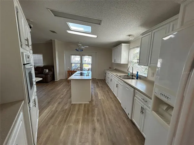 a view of a dining room with furniture a kitchen and chandelier