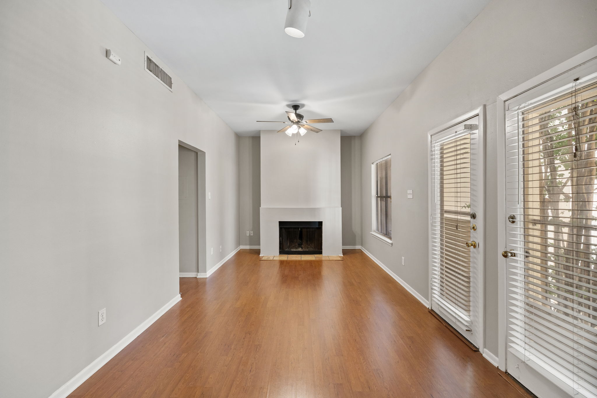 712 Graham Place, Unit 203 Austin, TX 78705 - Photo 5 of 30 a view of a livingroom with a fireplace a ceiling fan and brick wall