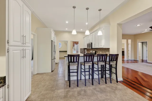 a kitchen with granite countertop a refrigerator stove top oven and sink