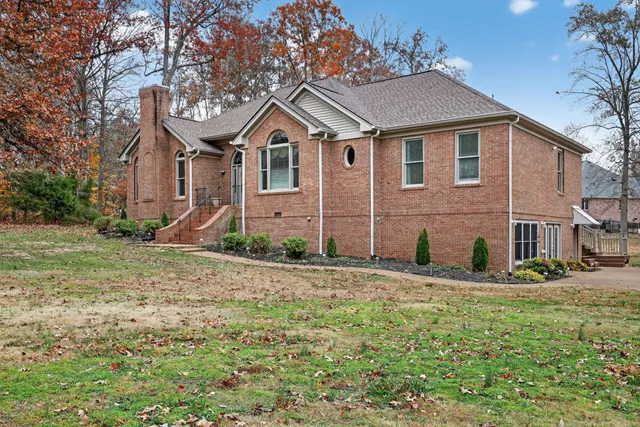 a view of a hallway with wooden floor and a chandelier