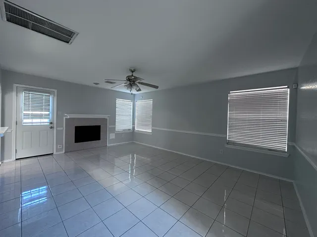 an empty room with windows and fireplace