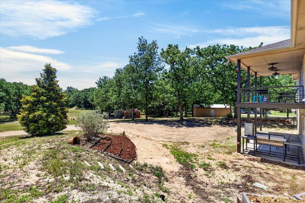 11591 Farm To Market 59 Athens, TX 75751 - Photo 30 of 40 Expansive outdoor area featuring a two-story covered patio, mature trees, and a detached outbuilding