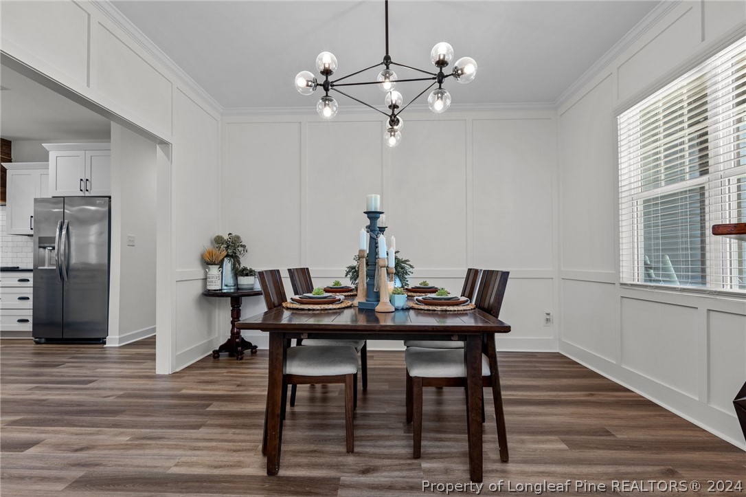 15420 Raccoon Run Road Wagram, NC 28396 - Photo 14 of 39 a view of a dining room with furniture a chandelier and wooden floor