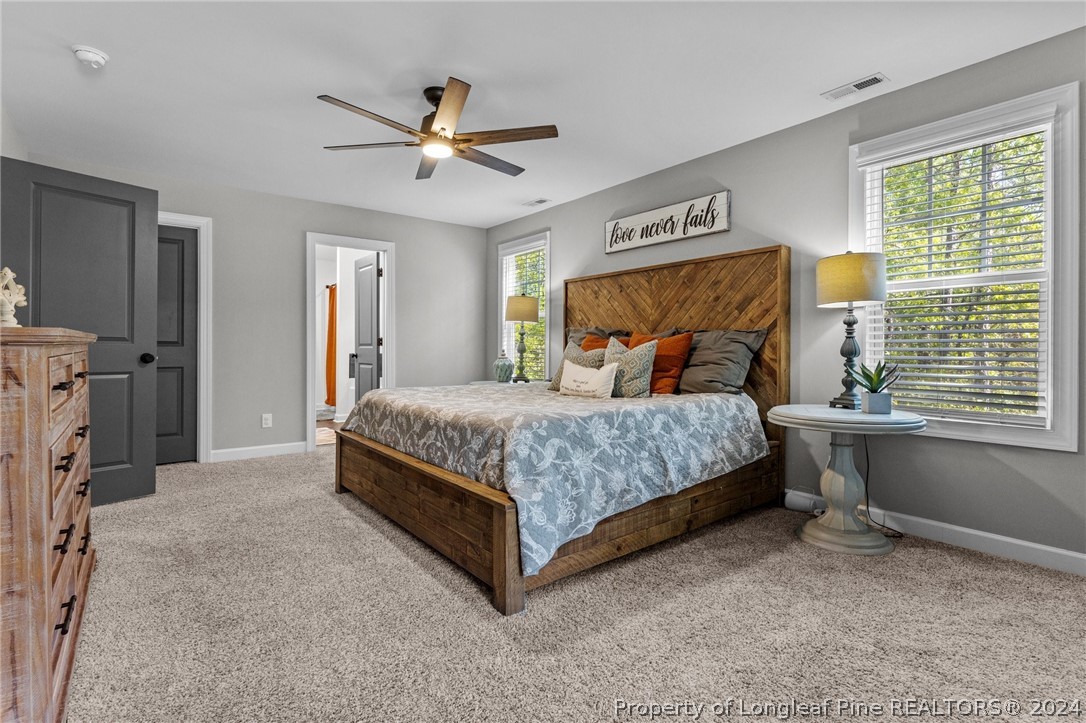 15420 Raccoon Run Road Wagram, NC 28396 - Photo 17 of 39 a bedroom with a bed and a chandelier