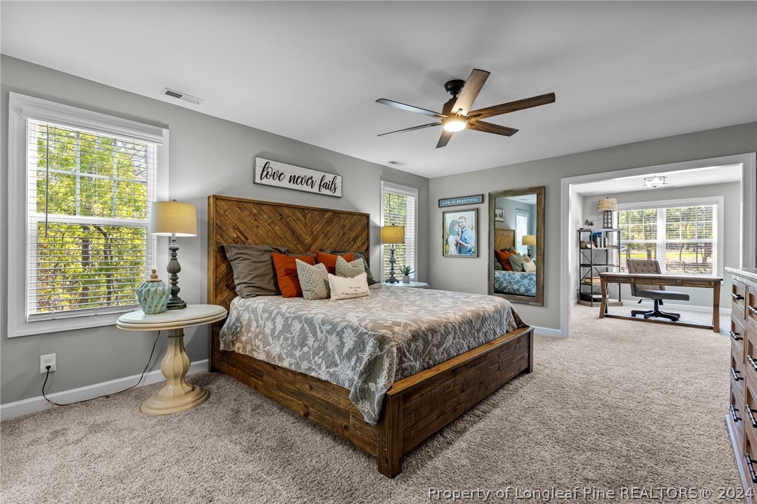 15420 Raccoon Run Road Wagram, NC 28396 - Photo 18 of 39 a bedroom with a bed and large windows