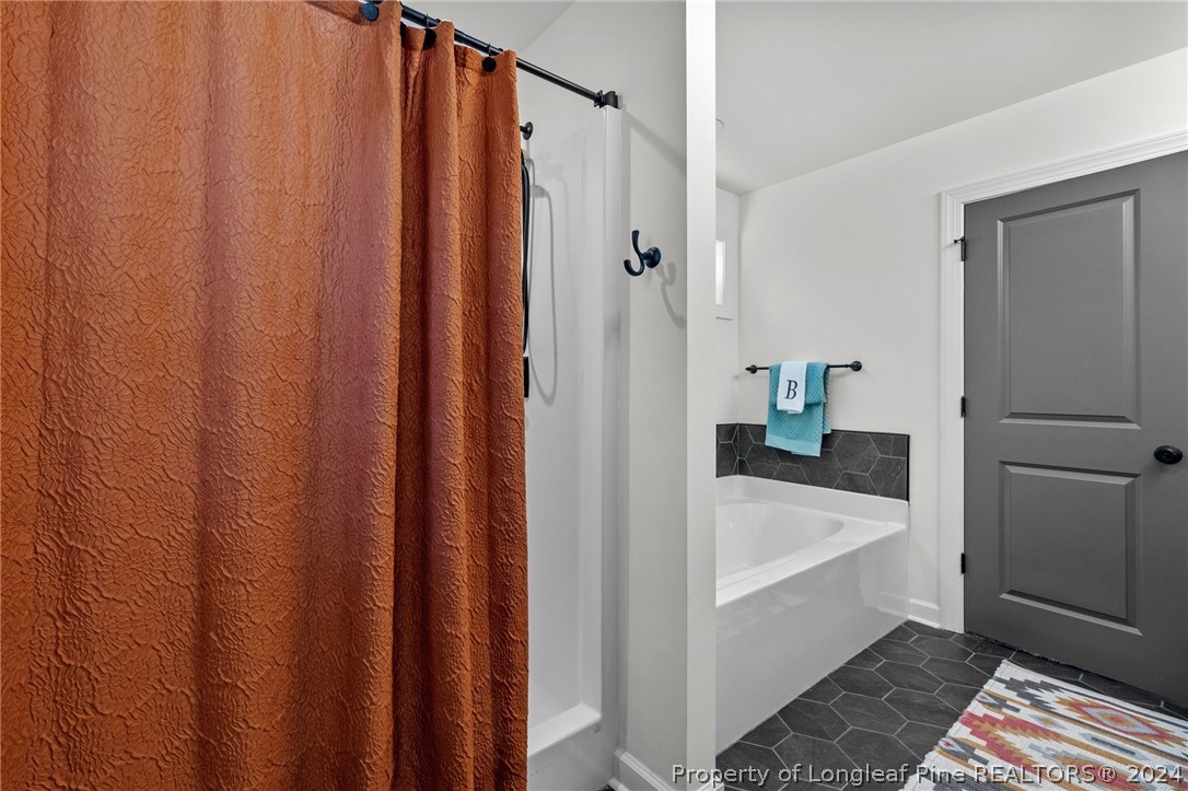 15420 Raccoon Run Road Wagram, NC 28396 - Photo 21 of 39 a bathroom with a bathtub and a shower