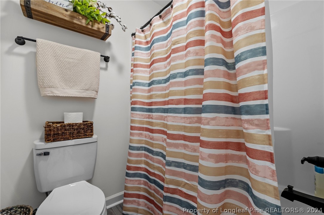 15420 Raccoon Run Road Wagram, NC 28396 - Photo 25 of 39 a white toilet sitting next to a shower curtain
