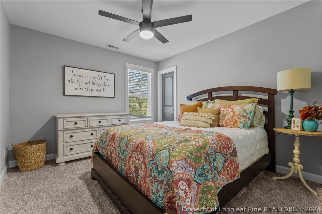 15420 Raccoon Run Road Wagram, NC 28396 - Photo 26 of 39 a bedroom with a bed and a lamp on dresser