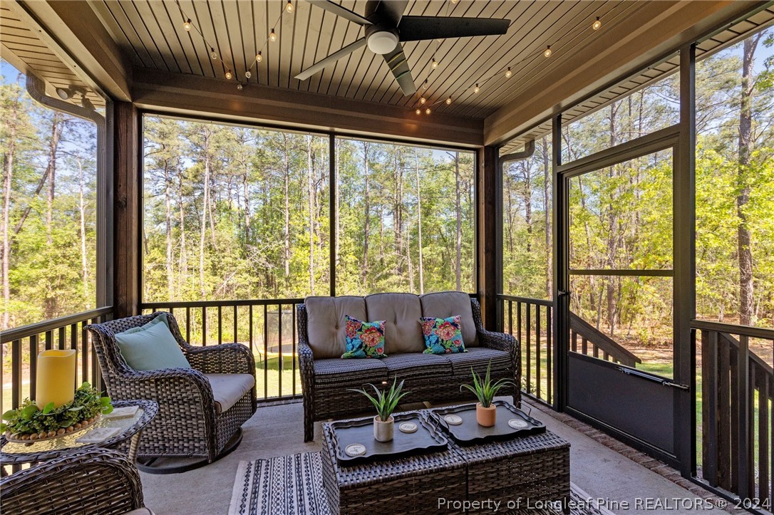 15420 Raccoon Run Road Wagram, NC 28396 - Photo 32 of 39 a living room with furniture and a floor to ceiling window