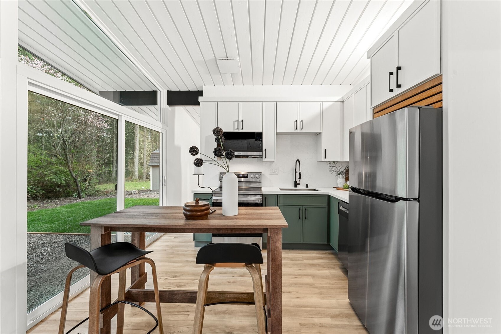 6198 Clover Valley Road Southeast Port Orchard, WA 98367 - Photo 10 of 34 a kitchen with a table chairs refrigerator and microwave