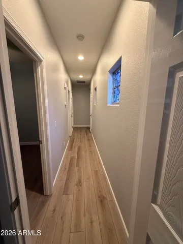 a view of a hallway with wooden floor