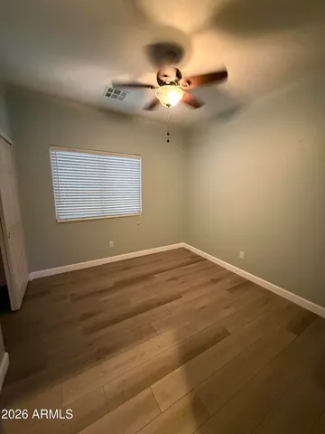 an empty room with a ceiling fan and window
