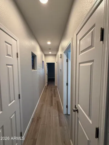 a view of a hallway with wooden floor and staircase