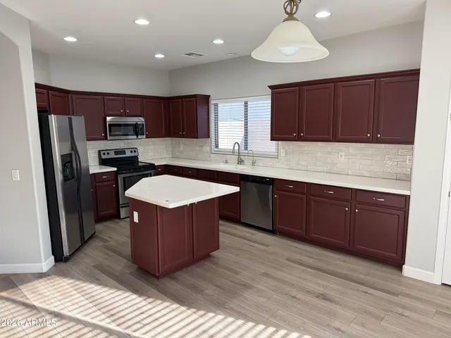 a kitchen with wooden cabinets sink and stainless steel appliances