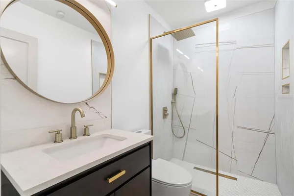 a bathroom with a sink and mirror with toilet