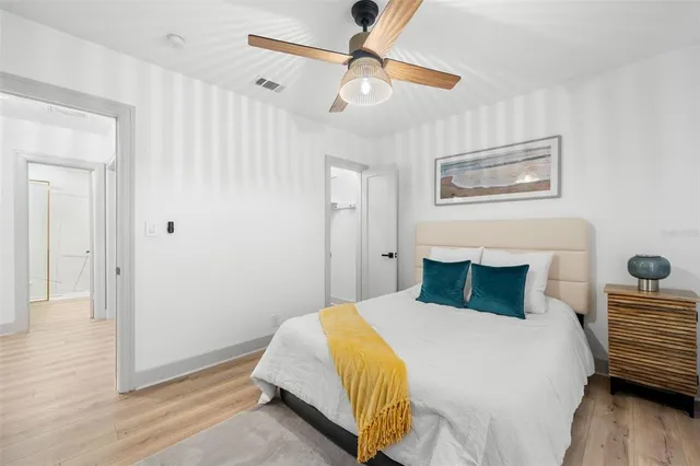 a bedroom with a bed and wooden floor