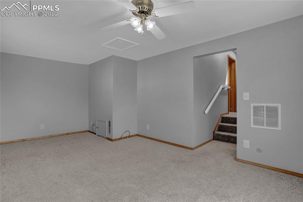1024 Prairie Road Colorado Springs, CO 80909 - Photo 11 of 22 an empty room with windows and stairs