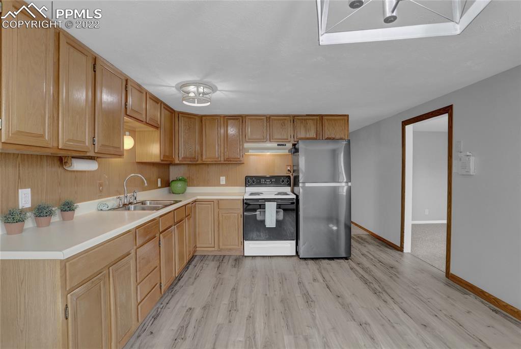 1024 Prairie Road Colorado Springs, CO 80909 - Photo 7 of 22 a kitchen with a sink cabinets stainless steel appliances and a window