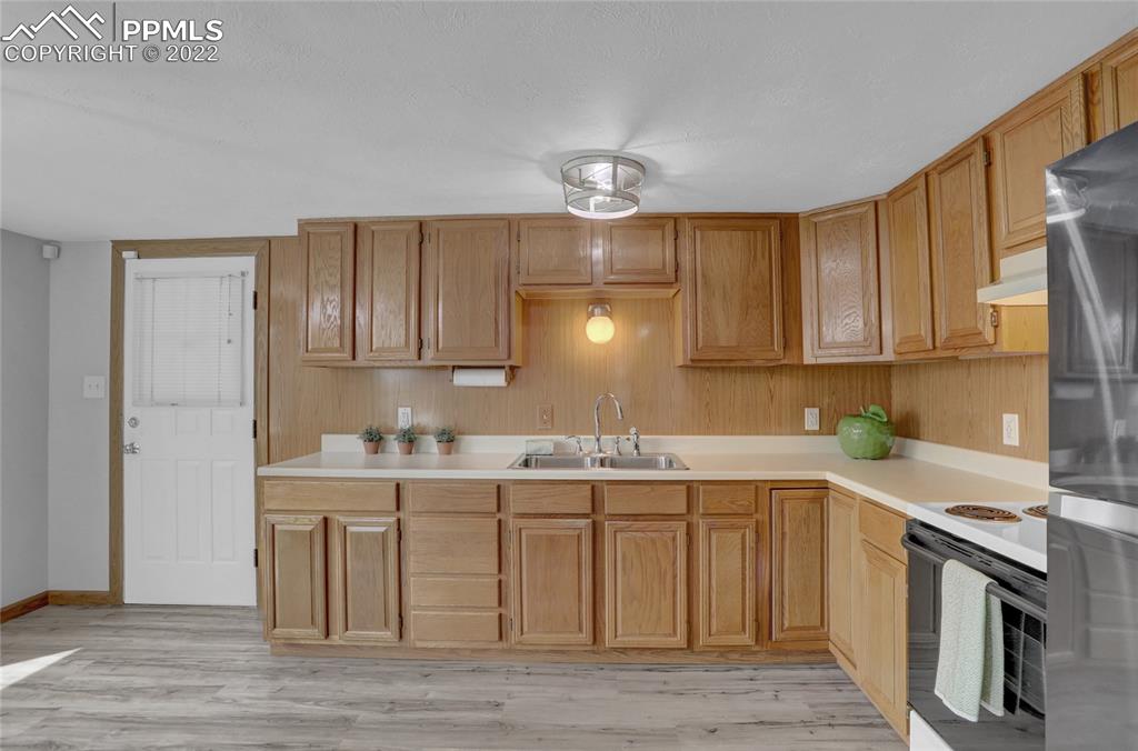 1024 Prairie Road Colorado Springs, CO 80909 - Photo 9 of 22 a kitchen with a sink cabinets and stainless steel appliances
