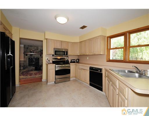 7 Doyle Road Old Bridge, NJ 07747 - Photo 4 of 10 a kitchen with stainless steel appliances granite countertop a sink and cabinets