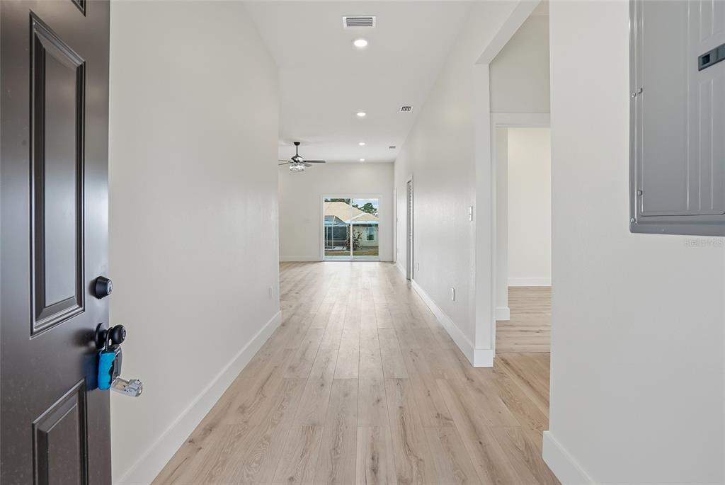 11256 Salters Street Spring Hill, FL 34609 - Photo 12 of 46 a view of a hallway with wooden floor and staircase