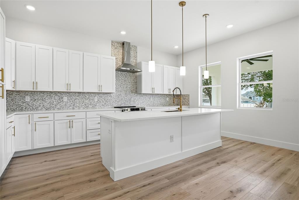 11256 Salters Street Spring Hill, FL 34609 - Photo 16 of 46 a kitchen with kitchen island white cabinets and white appliances